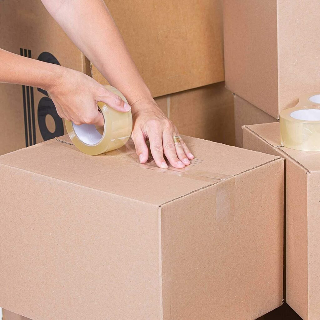 Carton box being sealed with clear tape on packing line